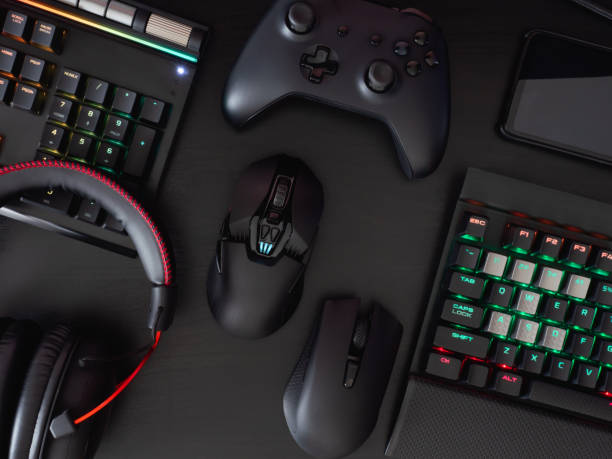 istock gamer work space concept, top view a gaming gear, mouse, keyboard, joystick, headset, mobile joystick, in ear headphone and mouse pad on black table background. 1208144904