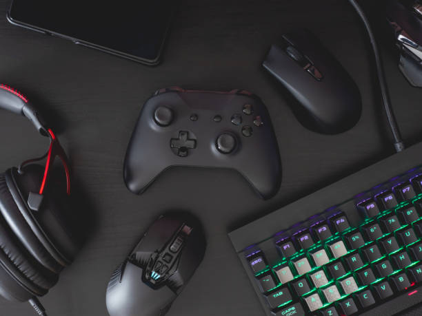 istock gamer work space concept, top view a gaming gear, mouse, keyboard, joystick, headset, mobile joystick, in ear headphone and mouse pad on black table background. 1208144920