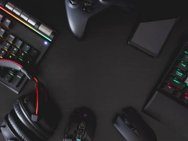 istock gamer work space concept, top view a gaming gear, mouse, keyboard, joystick, headset, mobile joystick, in ear headphone and mouse pad on black table background. 1208144925
