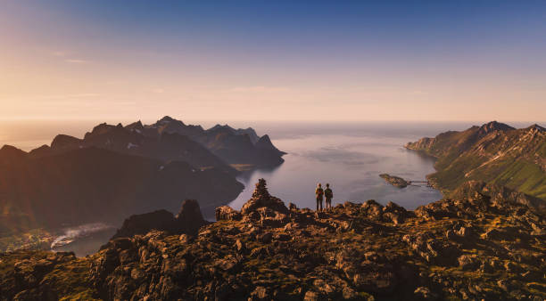 travel and adventure banner background, couple of travellers travel and adventure banner background, couple of travellers backpackers standing on top of the mountain in Senja, Norway senja island photos stock pictures, royalty-free photos & images