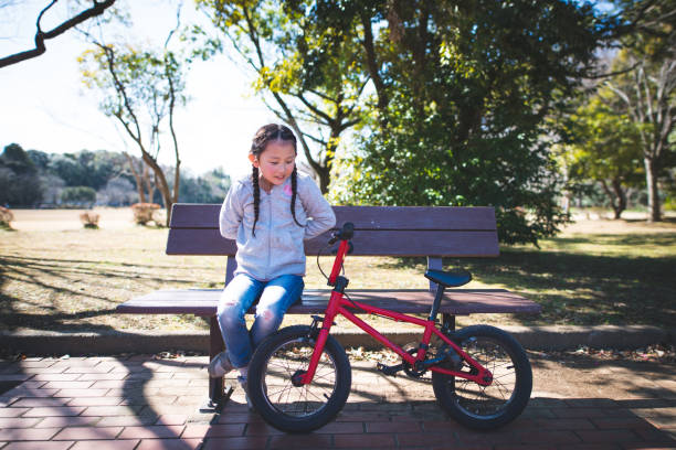 istock Girl relaxing on a park bench 1208154044