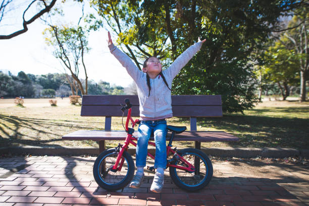 istock Girl relaxing on a park bench 1208154157