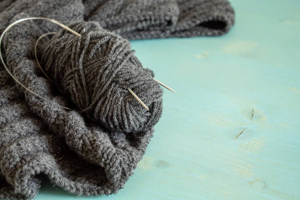 istock A ball of wool and grey knitting on a blue background 1208154792