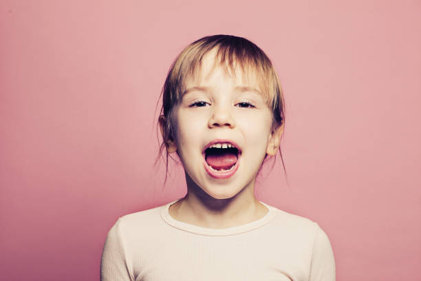 istock Child girl screaming on pink background 1208154993