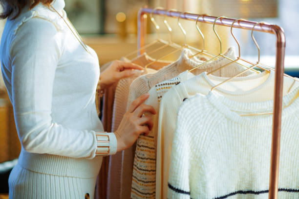 istock Closeup on elegant woman choosing sweaters hanging on rack 1208156013