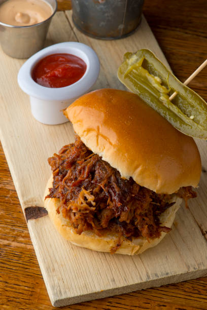 istock Pulled Pork Sandwich,  Barbecue meat sandwiches.  Brisket, beef ribs, pork ribs, bbq chicken or turkey served on traditional white hamburger buns. Traditional classic Texas style bbq. 1208157719