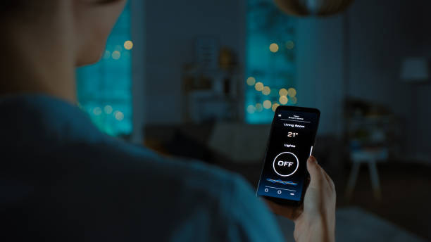 Close Up Shot of a Smartphone with Active Smart Home Application. Young Woman is Tapping the Screen to Turn On The Light in the Room. It's Cozy Evening in the Apartment. Close Up Shot of a Smartphone with Active Smart Home Application. Young Woman is Tapping the Screen to Turn On The Light in the Room. It's Cozy Evening in the Apartment. hot vietnamese women pictures stock pictures, royalty-free photos & images