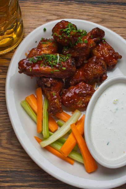 alitas de pollo. clásicas alitas tradicionales de pollo de búfalo picante servidas con salsas estándar de rancho y queso azul. restaurante americano clásico o bar favorito aperitivo. - wing spicy chicken wings chicken sauces fotografías e imágenes de stock