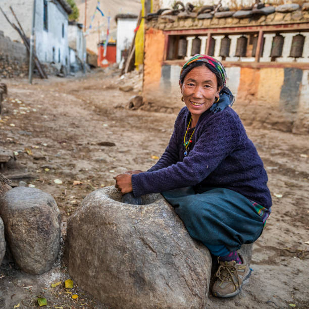 istock Tibetan woman using a stone mortar to make flour, Upper Mustang, Nepal 1208168255