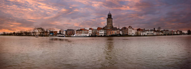 Panorama photo taken in winter of the Hanseatic city of Deventer Panorama photo taken in winter of the Hanseatic city of Deventer on the other side of the river IJssel, with beautiful colored cloudy skies deventer photos stock pictures, royalty-free photos & images