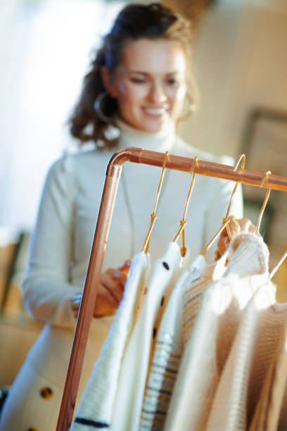 istock Closeup on smiling woman choosing sweaters hanging on rack 1208170154