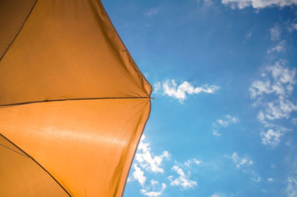 istock yellow umbrella on blue sky with clouds 1208171239