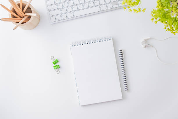 istock Flat lay blogger or freelancer workspace with a laptop, branches with green leaves, office supplies on a light background 1208172567