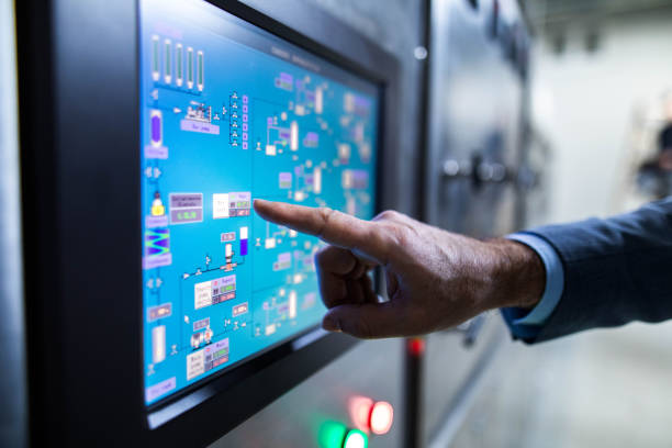 Close up of an inspector working on touch screen of production machine. Close up of unrecognizable inspector aiming at data on a machine in a factory. computer aided manufacturing photos stock pictures, royalty-free photos & images