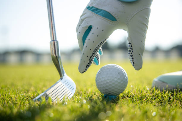 istock Hand in glove placing golf ball on tee 1208177943