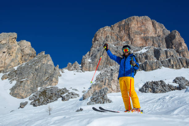 skifahrer stehen auf piste in winterbergen - cortina dampezzo stock-fotos und bilder