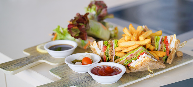 Club sandwich. Turkey club sandwich served with french fries and ketchup. Soft focus and copy space.