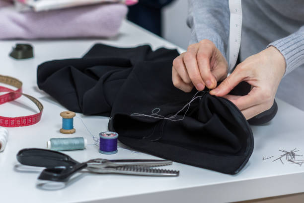 istock Seamstress is stitching zipper to black wide-leg pants 1208182897