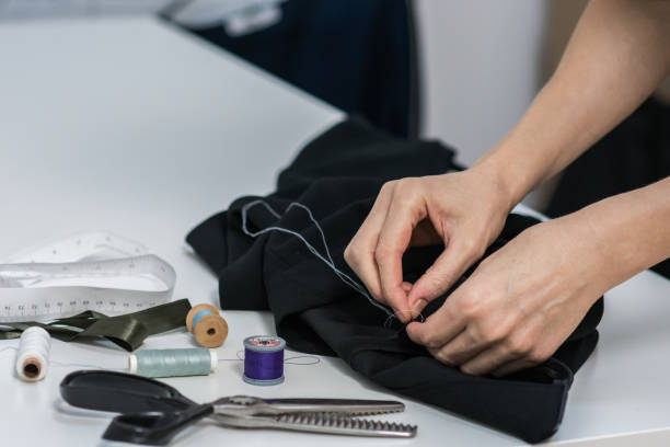 istock Seamstress is stitching zipper to black wide-leg pants 1208182911
