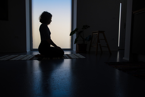 Young adult woman doing yoga at home, embodiment and awareness through movement, Feldenkrais Method