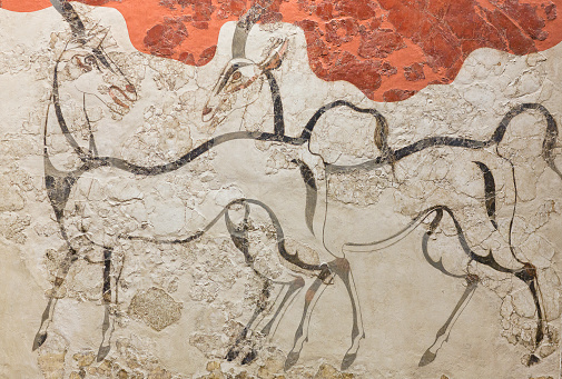 Thera, Santorini island, Cyclades, Greece - March 16, 2018: Wild antelopes - wall painting fresco in Akrotiri Minoan Bronze Age settlement on the volcanic Greek island of Santorini. The Akrotiri site associated with the Minoan civilization. Akrotiri has been excavated since 1967.
