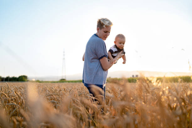 istock mother holding her baby on a wheat filed 1208188853