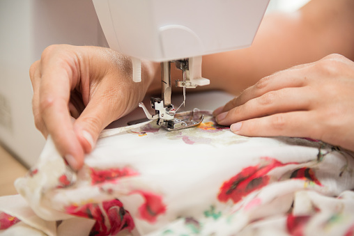 Young women, tailor, fashion designer working on sewing machine, dressmaking,fashion industry. Small business growing, learning to sew, education training class.