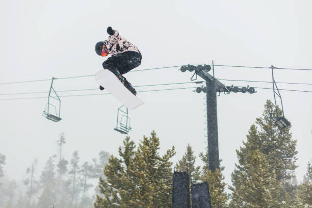 ski- und snowboardaktivitäten im ski resort town in den colorado rockies - ski jumping snowboarding snowboard jumping stock-fotos und bilder