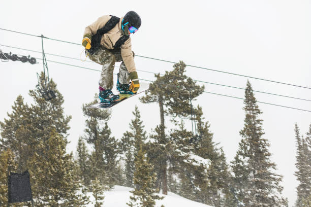 ski- und snowboardaktivitäten im ski resort town in den colorado rockies - ski jumping snowboarding snowboard jumping stock-fotos und bilder