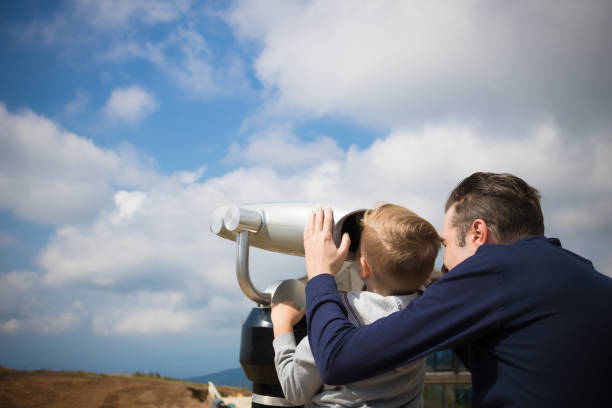 istock Father and son looking the sky through telescope. 1208193719