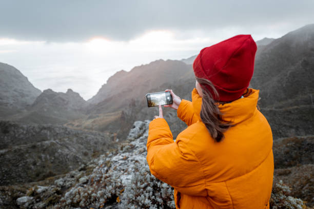 istock Woman photographing mountains while travel 1208193911