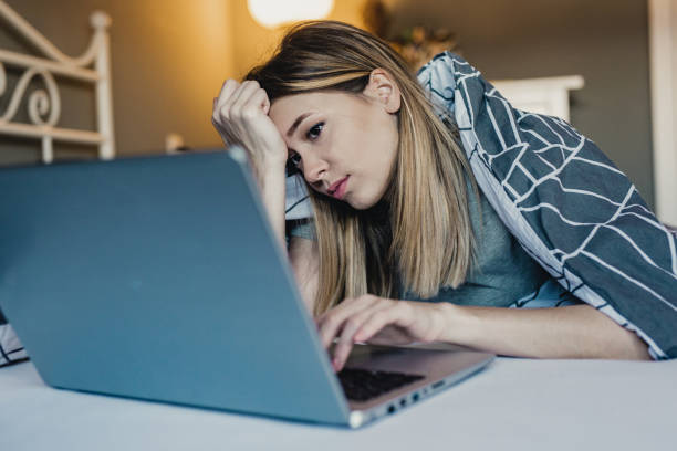 istock Young woman in bed working on the laptop 1208195233