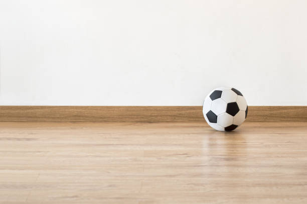 Soccer ball next to a white wall at home room with copy space