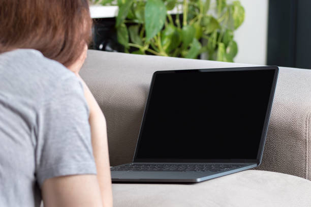 istock oman watching media content in a laptop 1208199082