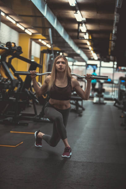 istock Attractive female athlete doing barbell lunges 1208200415