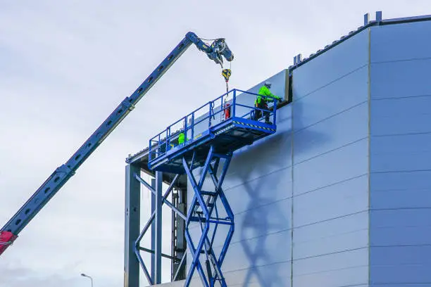 Photo of sandwich panels wall mounting using crane and scissor lift