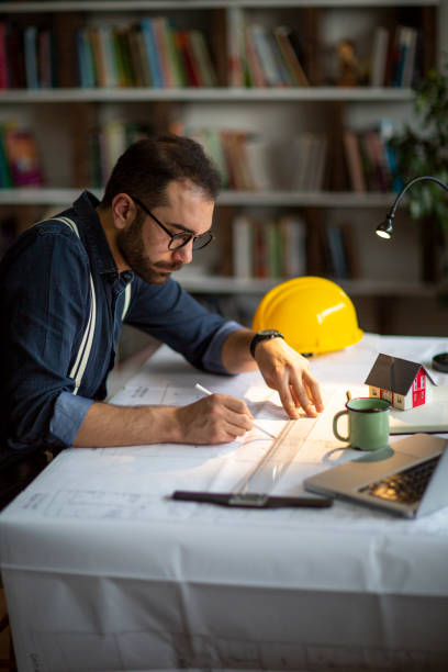 arquitecto trabajando con planos en la oficina central. - built structure coffee blueprint engineering fotografías e imágenes de stock