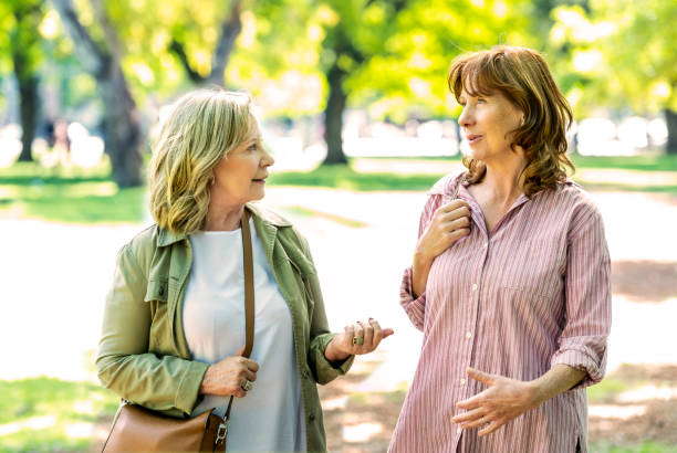 istock Two senior woman walking at the park 1208205884
