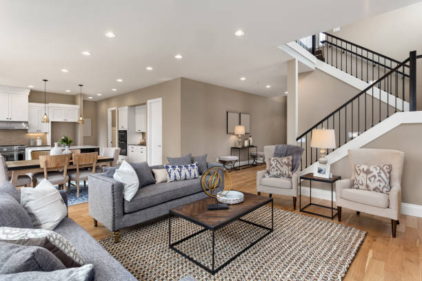 schönes wohnzimmer-interieur mit massivholzböden und blick auf die küche in neuem luxushaus - großraum stock-fotos und bilder
