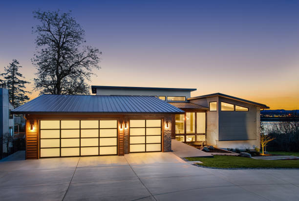 Beautiful modern luxury home exterior at sunset. Features contemporary design and three car garage
