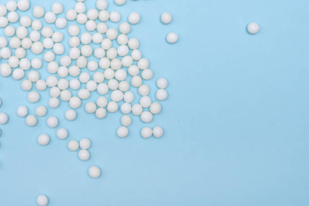 istock Many homeopathic globules scattered on pastel blue background, alternative homeopathy medicine concept, close up with copy space 1208206162