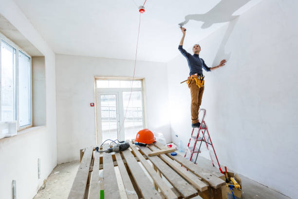 istock Thirty years old manual worker with wall plastering tools inside a house. Plasterer renovating indoor walls and ceilings with float and plaster. 1208207762