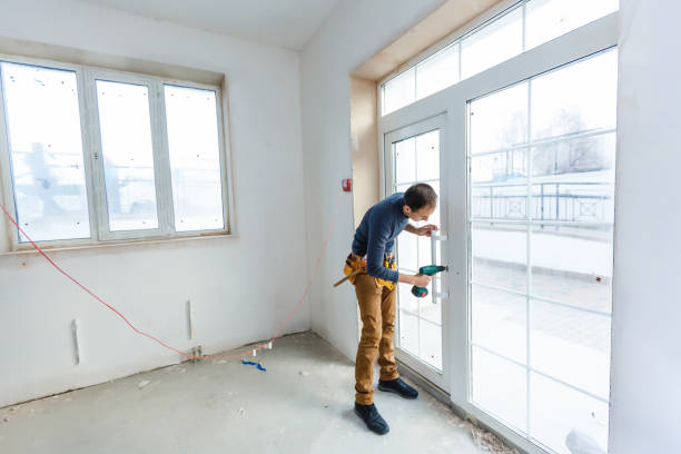 Worker in glazier's workshop, warehouse or storage handling glass