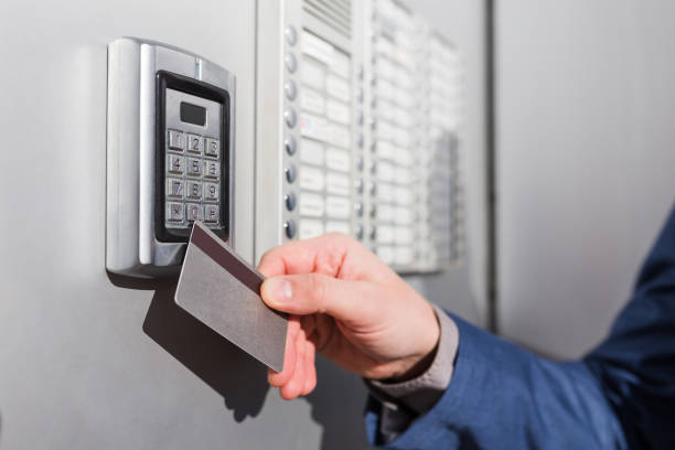 istock Door access control. Man hand holding key card to lock or unlock door. 1208209483