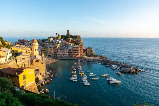 Photo of View of Vernazza and the ocean during sunset at Cinque Terre with blue sky