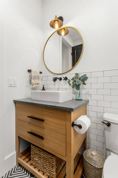 istock Beautiful bathroom interior in new luxury home with vanity, mirror, and cabinets 1208210874