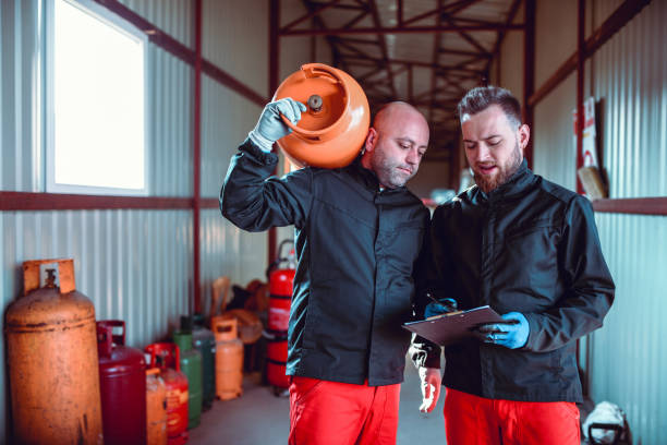 istock Male Workers In Liquified Gas Store Checking Schedule 1208211220