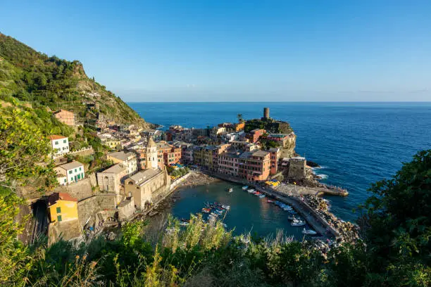 Photo of View of Vernazza and the ocean during sunset at Cinque Terre with blue sky