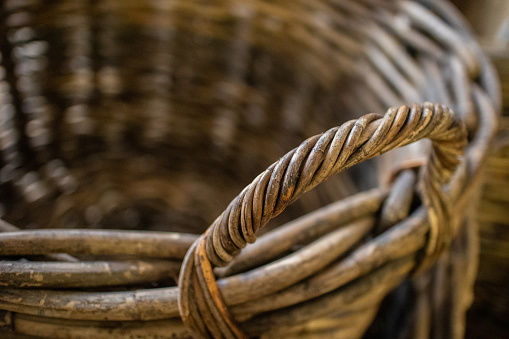 Close up of the handle of a rustic wicker basket