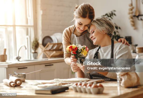Happy Mothers Day Family Old Grandmother Motherinlaw And Daughterinlaw Daughter Congratulate On Holiday Give Flowers Stock Photo - Download Image Now